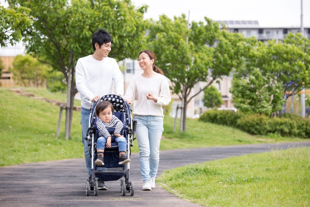 若い夫婦がベビーカーを押す様子